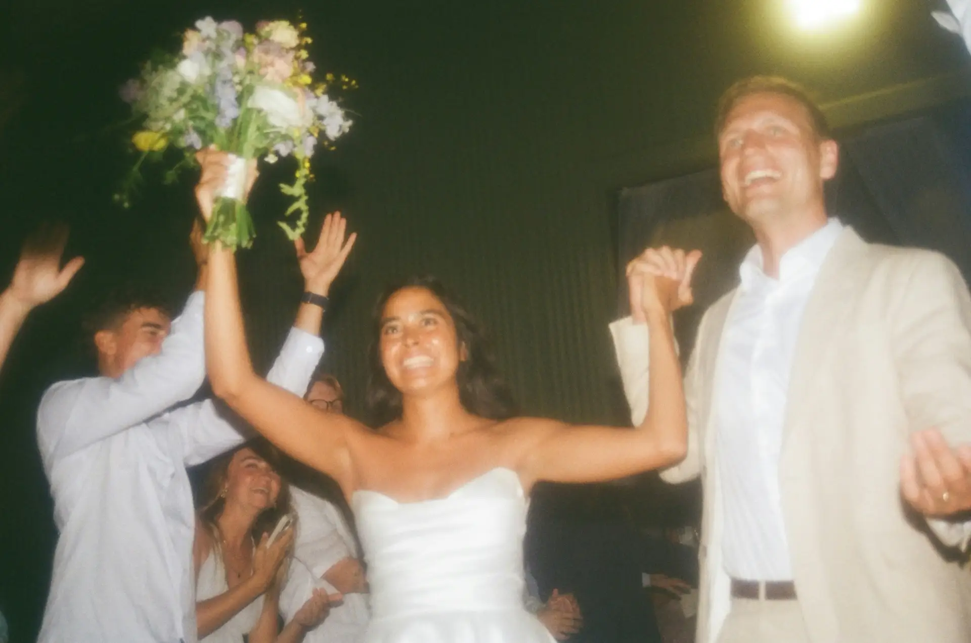 Guests celebrating on a dancefloor, the kind of candid wedding energy a vintage camcorder catches